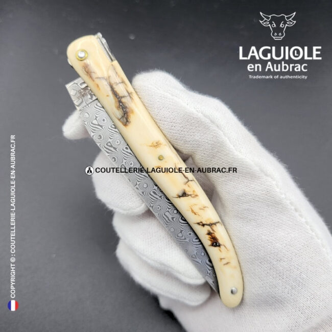 parchemin des glaces : couteau laguiole plein manche en croûte d'ivoire de mammouth – lame damas – or et zircons